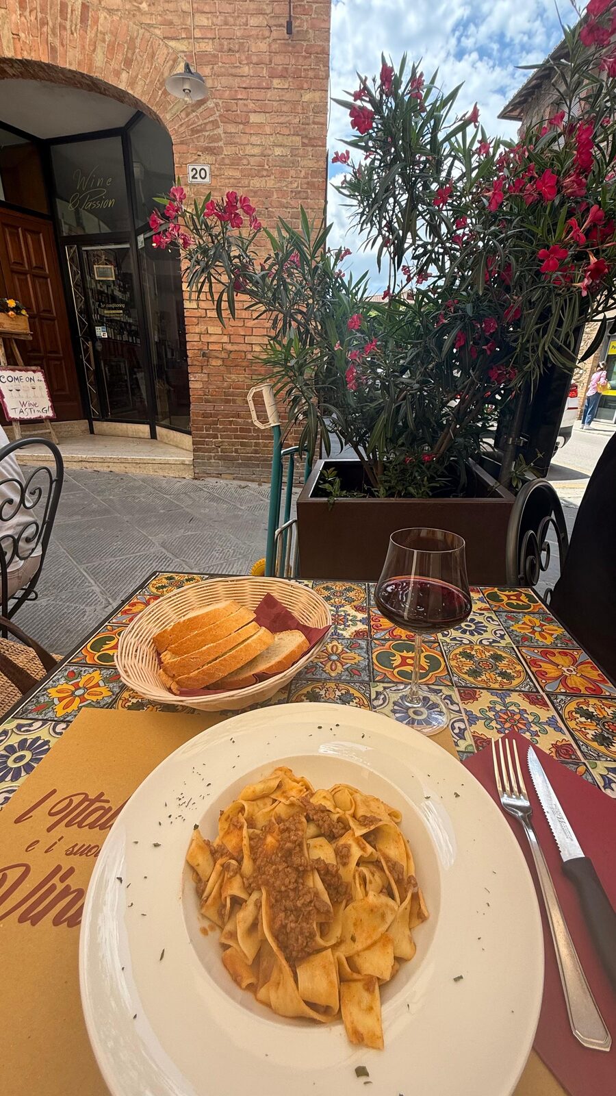 Pappardelle z sosem i lampka czerwonego wina na tarasie toskańskiej restauracji
