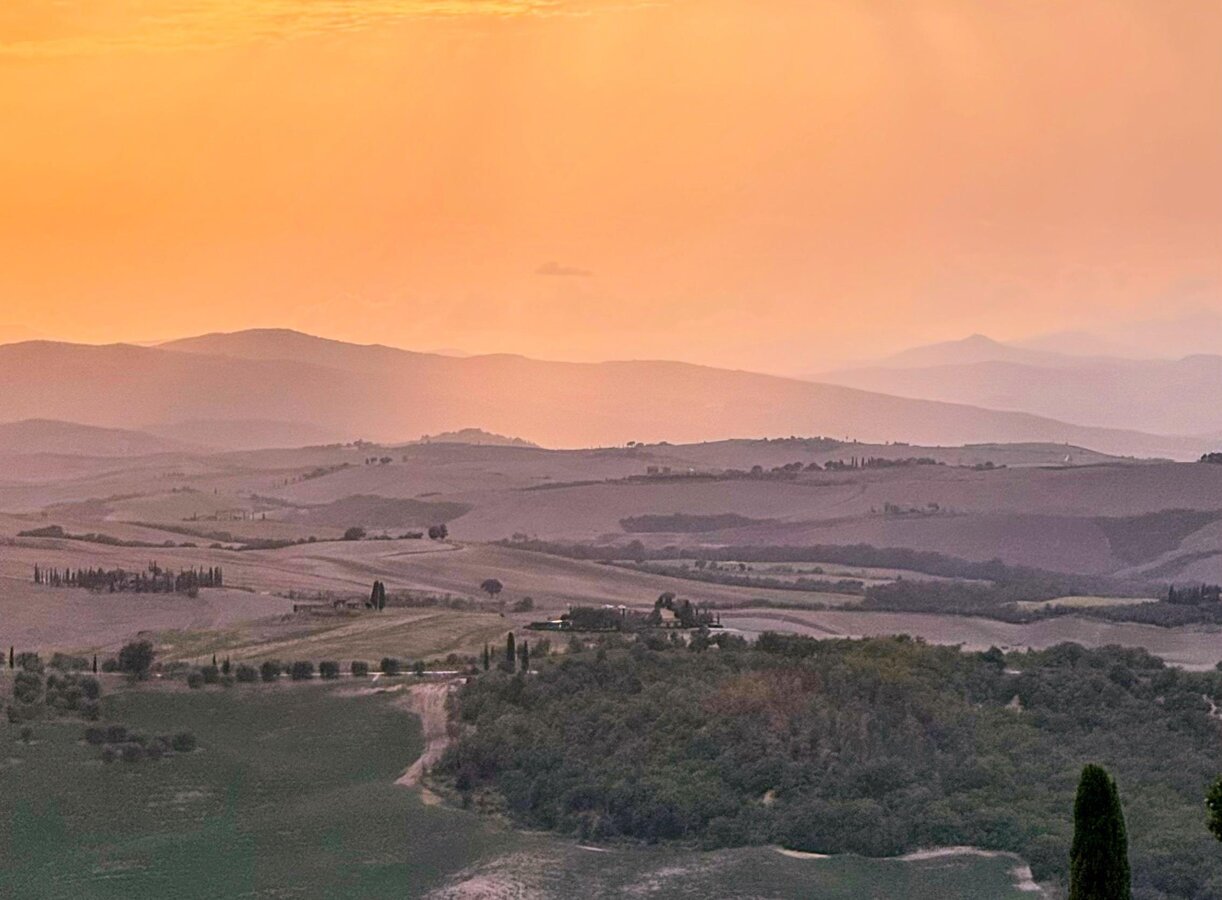 Zachód słońca nad wzgórzami doliny Val d'Orcia w okolicach Pienzy